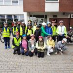 Grupa uczniów w kaskach rowerowych i kamizelkach odblaskowych przed szkoła w Paczkowie