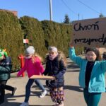 Uczniowie z transparentami i instrumentami wędrują po ulicach Paczkowa